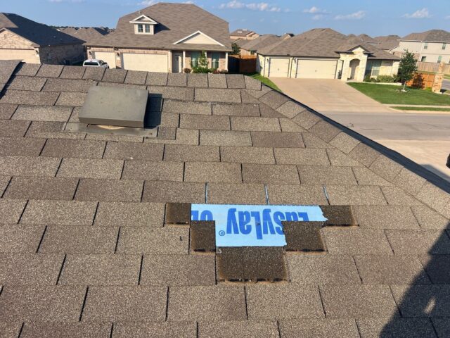 Missing shingles from wind showing exposed underlayment