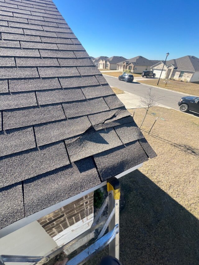 wind damage to shingles on front left corner of roof