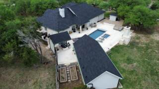 Aerial view from back yard of all roofs showing new IKO Dynasty shingles in Granite black 