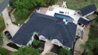 Aerial view from the front yard of all roofs showing new IKO Dynasty shingles in Granite black