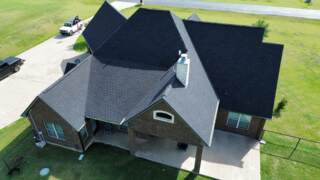 Aerial view of the back of the home showing new roof. Shingles are Pinnacle Atlas Class 4 in Shadow Black