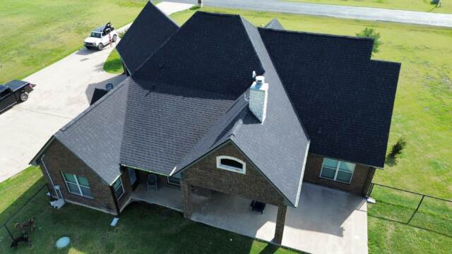 Aerial view of the back of the home showing new roof. Shingles are Pinnacle Atlas Class 4 in Shadow Black