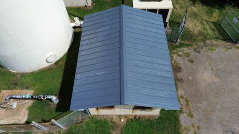 Aerial view of the new metal roof on the water companies old office. Metal roof is charcoal grey. 