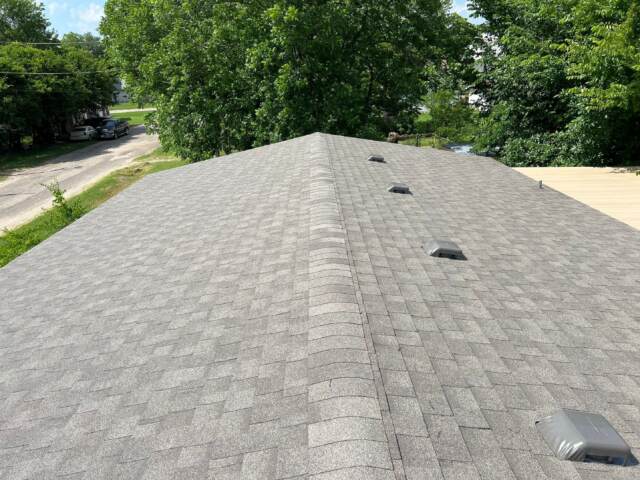 view from right side looking down the ridge showing the new shingles. Shingles are IKO Cambridge in Weatherwood