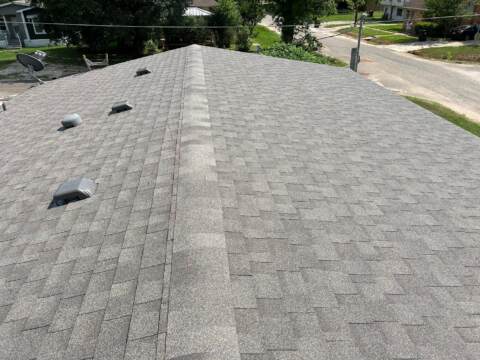 view from left side looking down the ridge showing the new shingles. Shingles are IKO Cambridge in Weatherwood