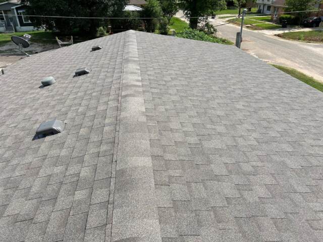 view from left side looking down the ridge showing the new shingles. Shingles are IKO Cambridge in Weatherwood