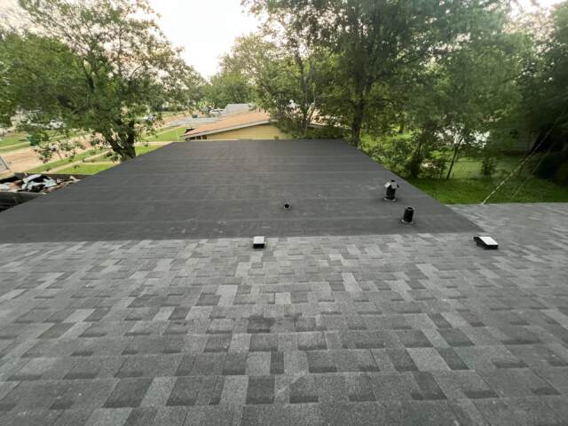 View showing the entire flat roof with new black rolled roofing to match main roof.