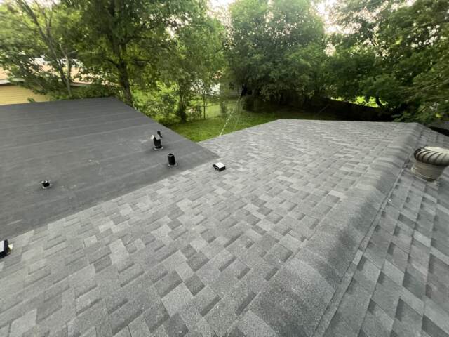 View of the left slope and flat roof section showing new shingles on main roof and rolled roofing on flat section. Shingles are IKO Cambridge in Dual Black