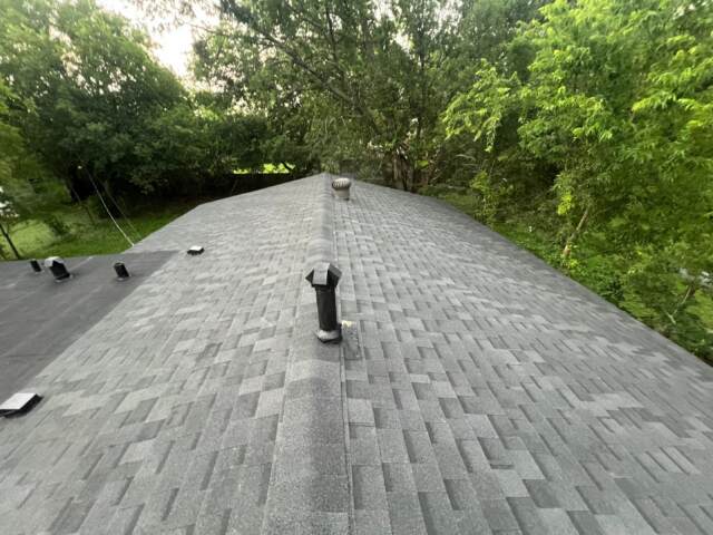 View of the roof looking down the ridge showing new shingles. Shingles are IKO Cambridge in Dual Black