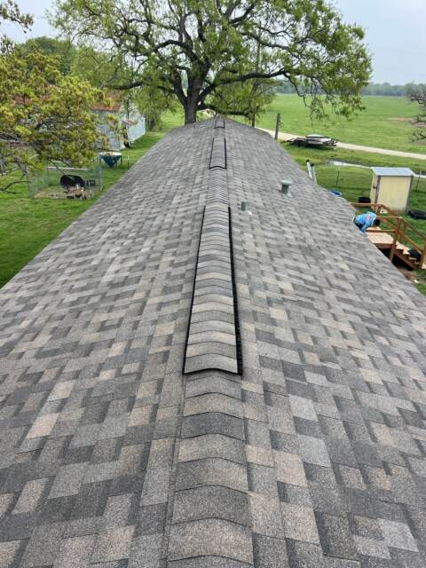 View of new roof looking down the ridge from the left side. Shingles are IKO Dynasty in Driftshake